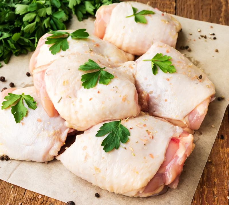 Raw Chicken Thighs With Parsley On Wooden Table
